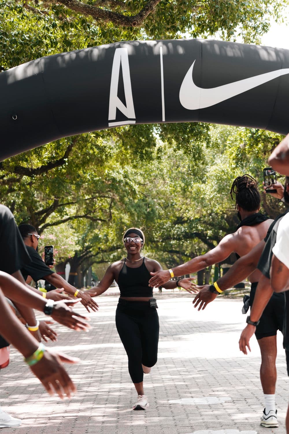 A SoleTies runner crossing the finish line to cheering teammates